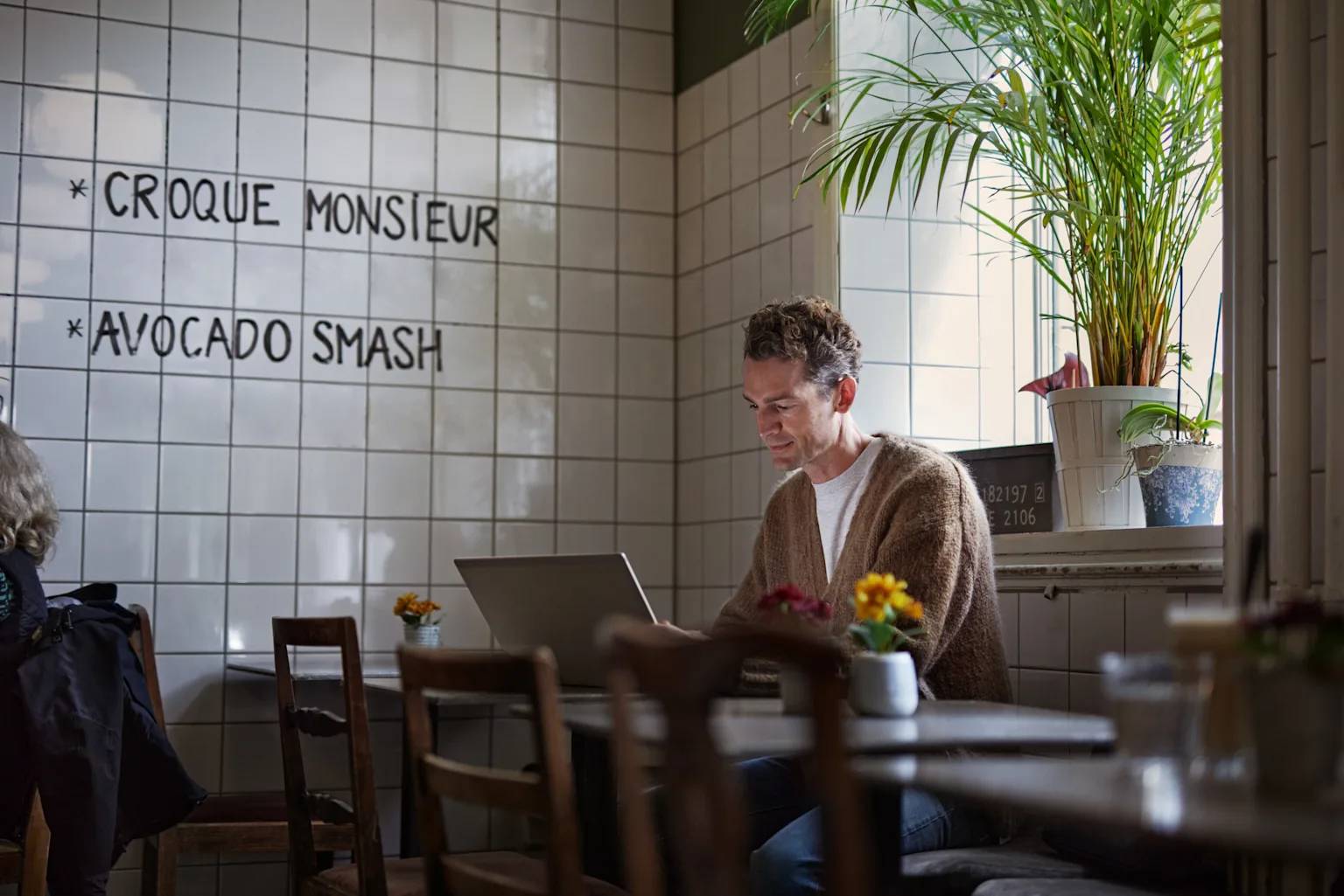 Man framför laptop på café