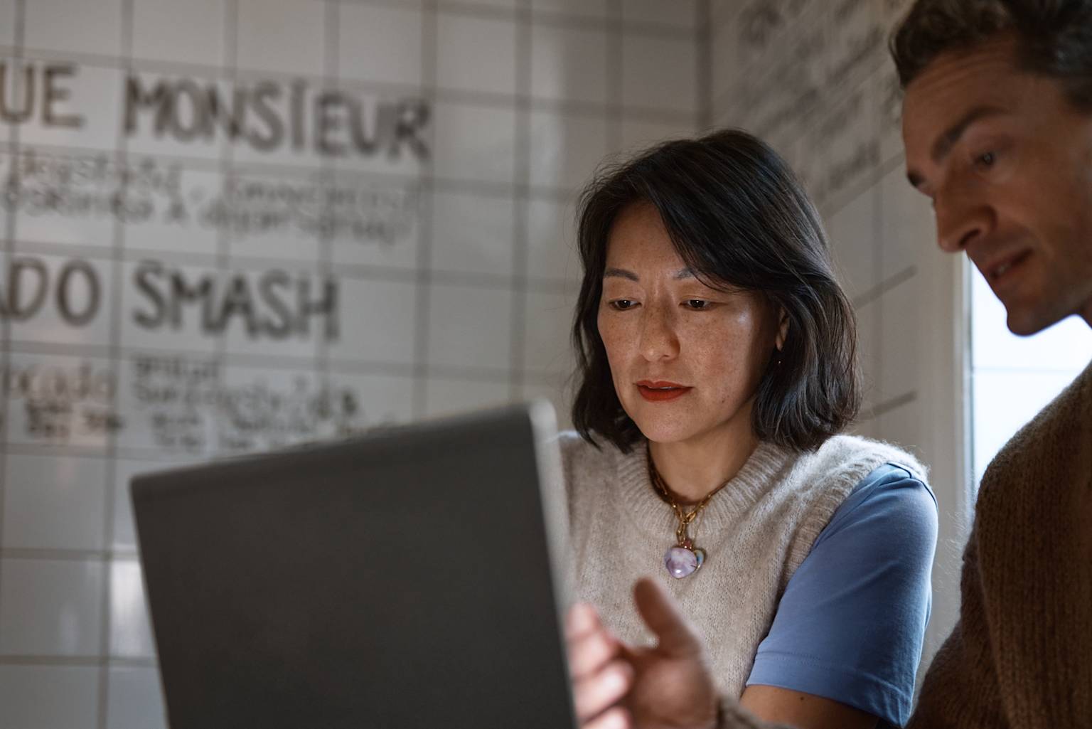 Kvinna och man jobbar i Microsoft 365 på kafé.