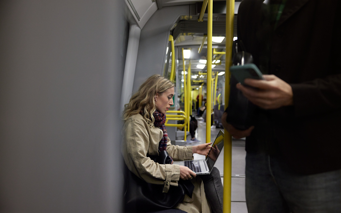 Kvinna arbetar med mobilt bredband på tunnelbanan.