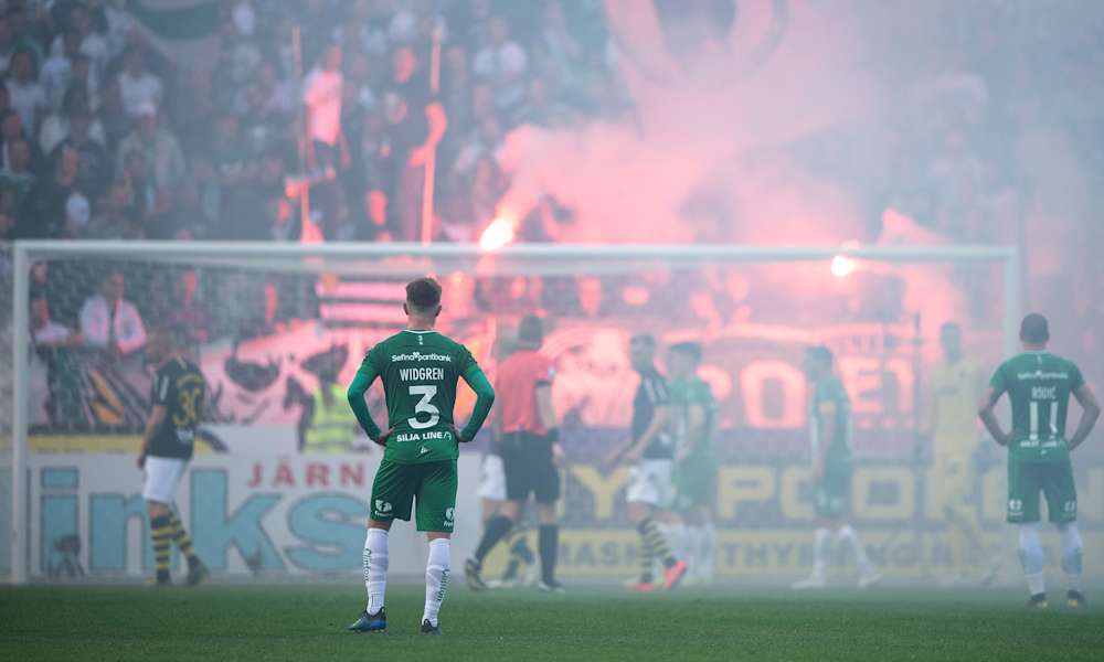 Hammarbyspelare i förgrunden under ett spelavbrott 2019 på grund av bengaliska eldar.