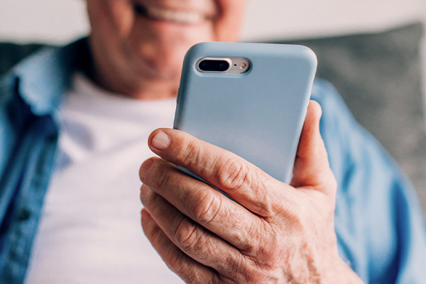 Närbild på hand med mobiltelefon.