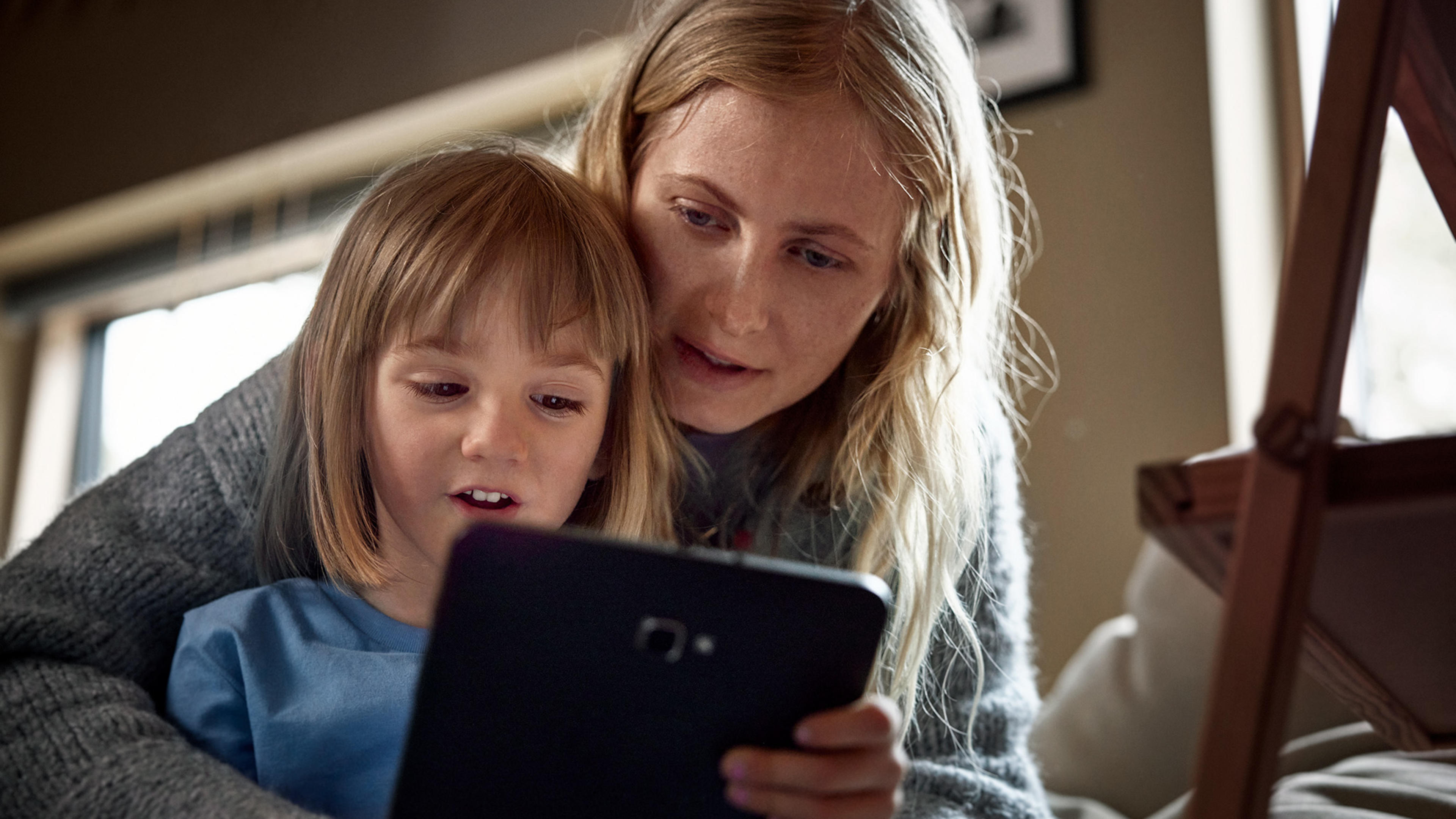 Familjemys - mamma och flicka streamar barnprogram på surfplatta.