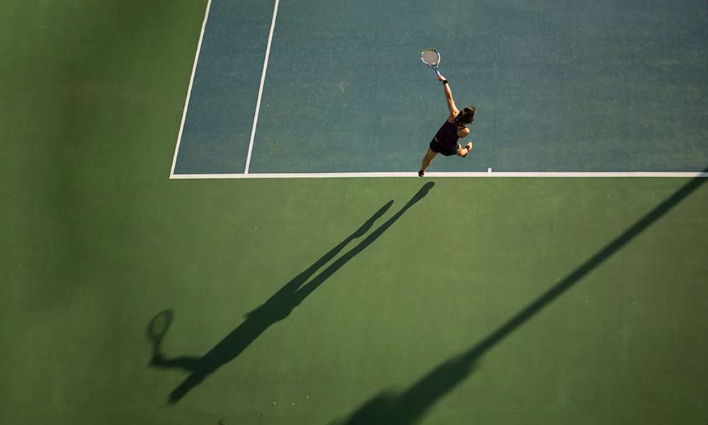 Tennis - tennisspelare på courten slår med tennisracket.