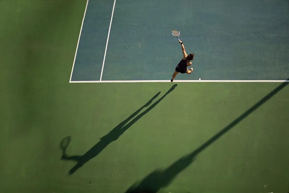 Tennis - tennisspelare på courten slår med tennisracket.