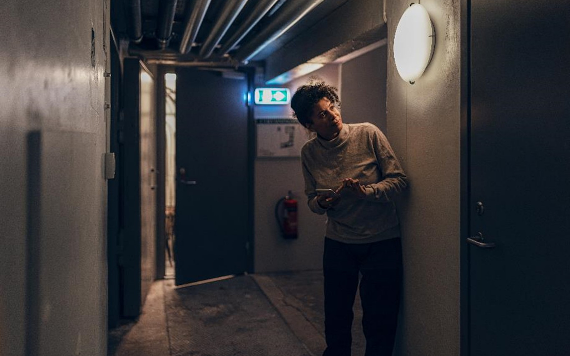 Kvinna står framför en dörr i en fastighets källarutrymme