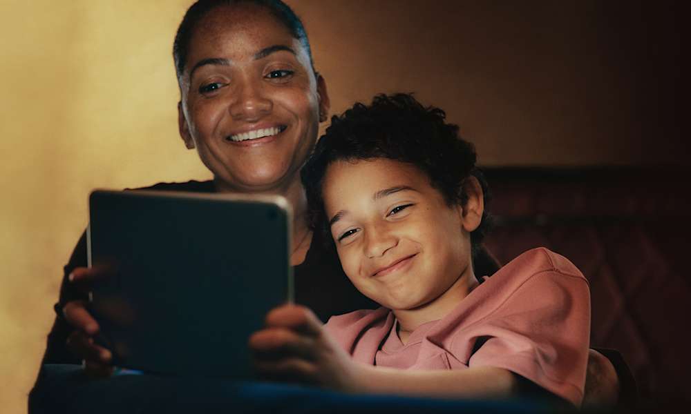 mamma och barn kollar på surfplatta