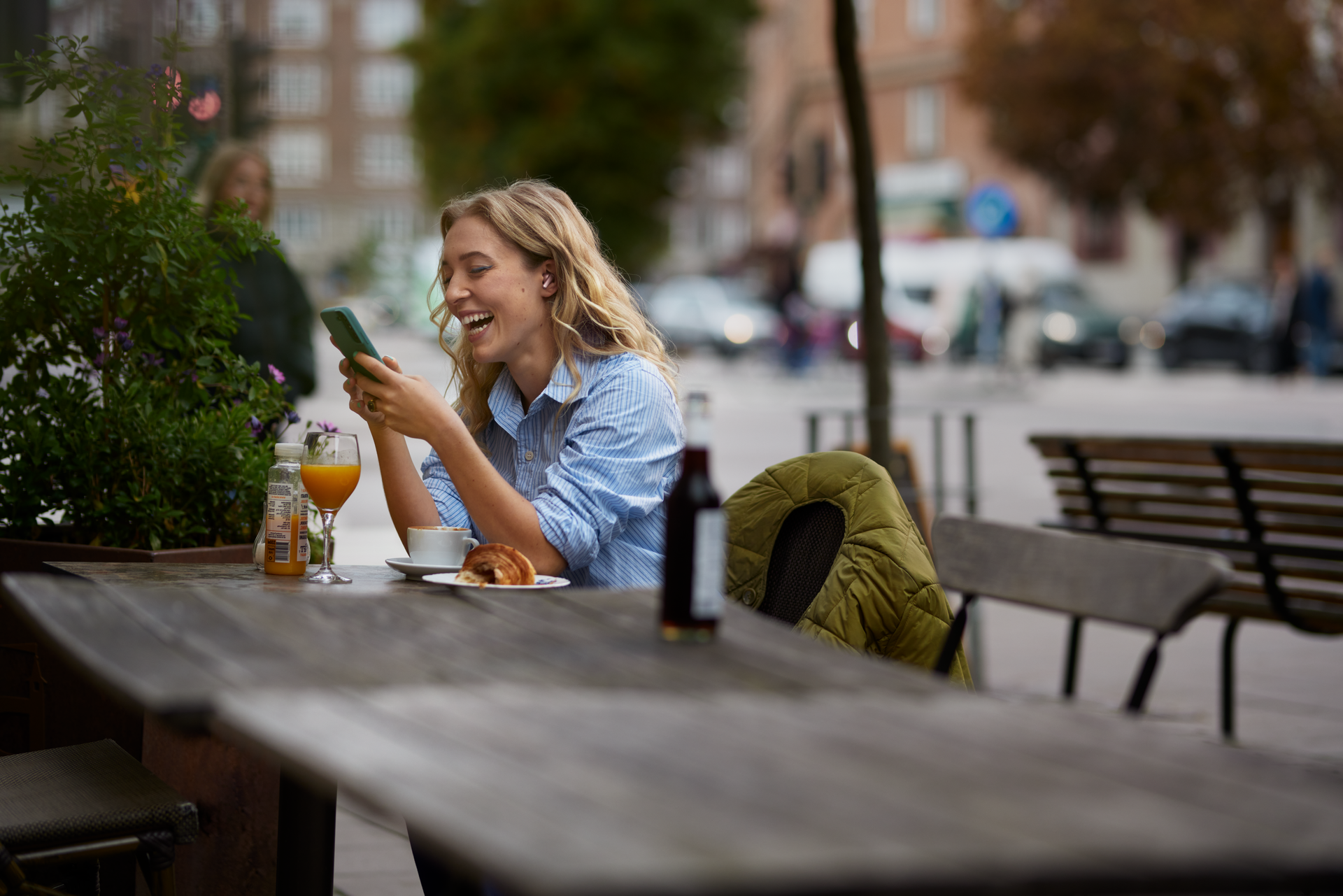 Kvinna arbetar med mobil i Telias nät på café