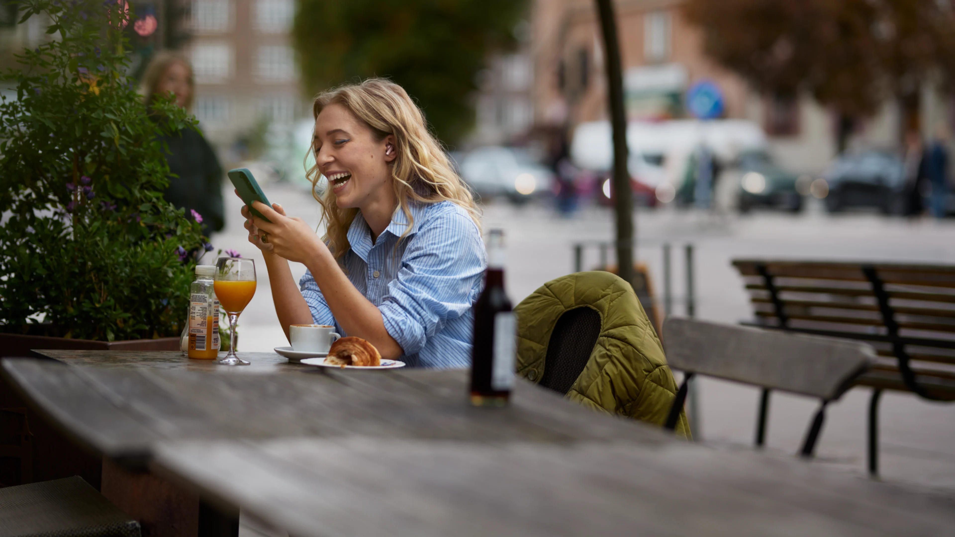 Kvinna arbetar med mobil i Telias nät på café