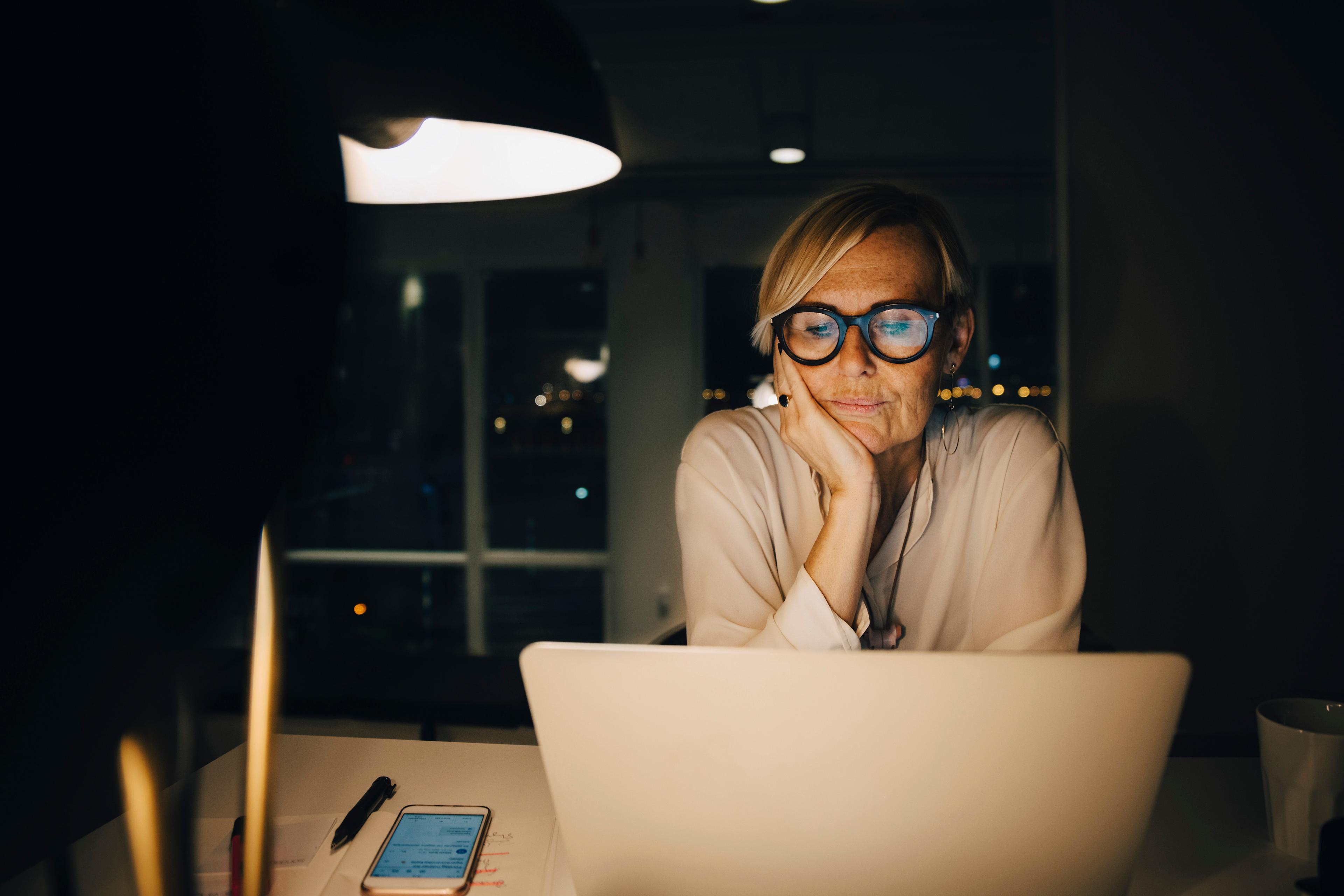 Kvinna som sitter framför dator och tittar på skärmen.