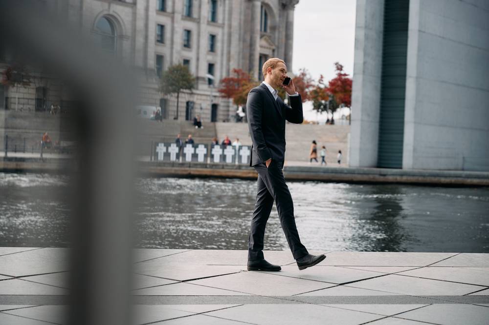 Affärsman går och pratar i telefon med företagsabonnemang 