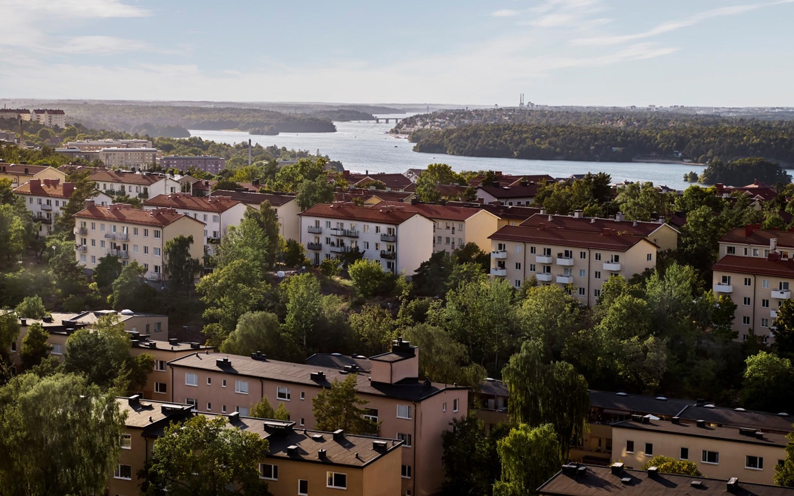 Flygbild över flervåningshus omgivna av skog