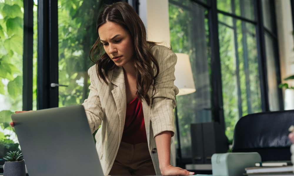 Kvinna vid laptop oroad över DDoS-attack på kontor
