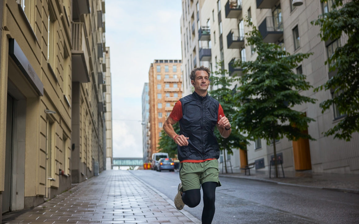 Man som springer på gata mellan hus