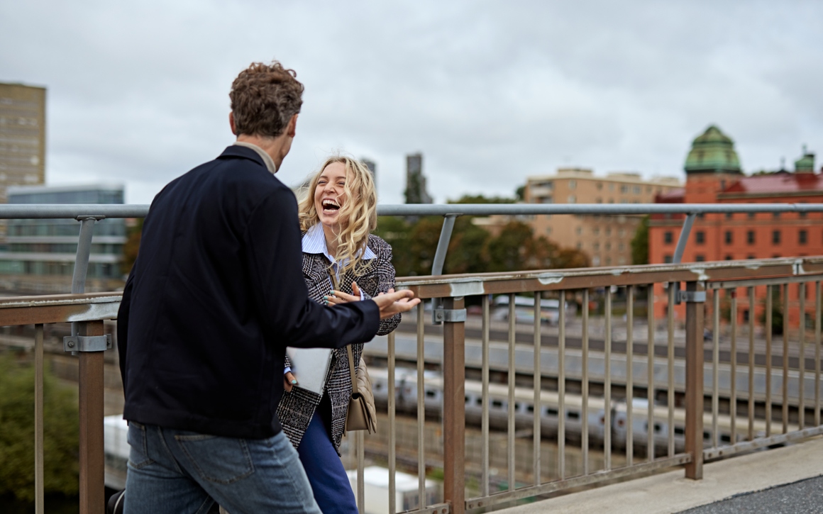Kvinna och man pratar på takterrass i Stockholm