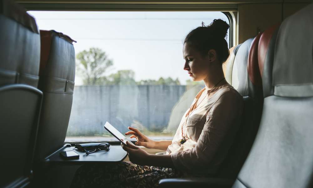 Kvinna på buss som arbetar på sin dator