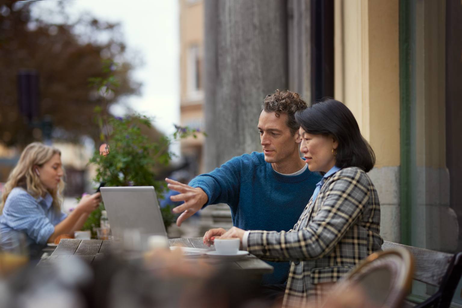 Kollegor arbetar med laptop med skydd för cybersäkerhet på café