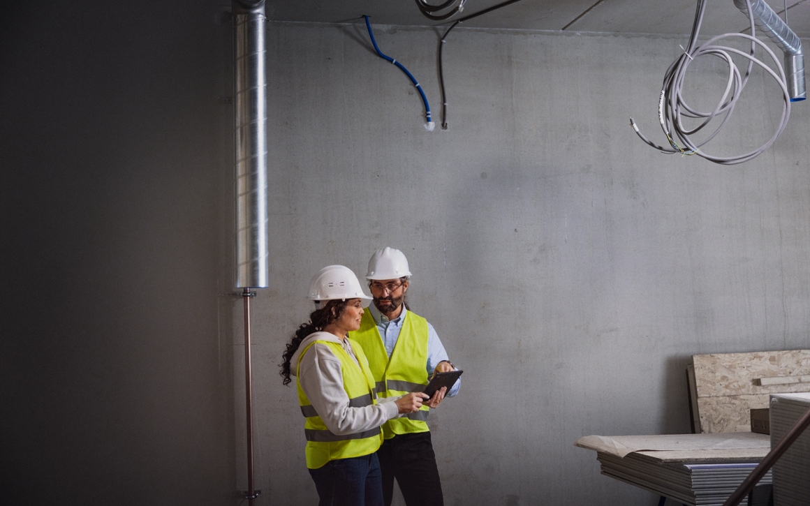 Man och kvinna med platta på byggarbetsplats